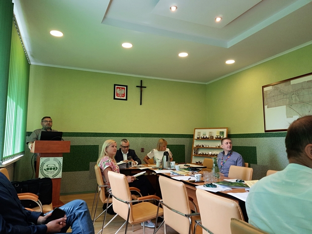 Na zdjęciu, za mównicą stoi Inspektor COBORU. Obok widać członków Zespołu, którzy siedzą za stołem.
